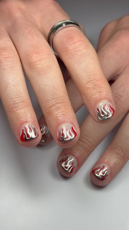 Nail art sur ongles courts : flammes chromées argentées et rouges, aussi bien pour elles que pour eux. Gossip Concept.