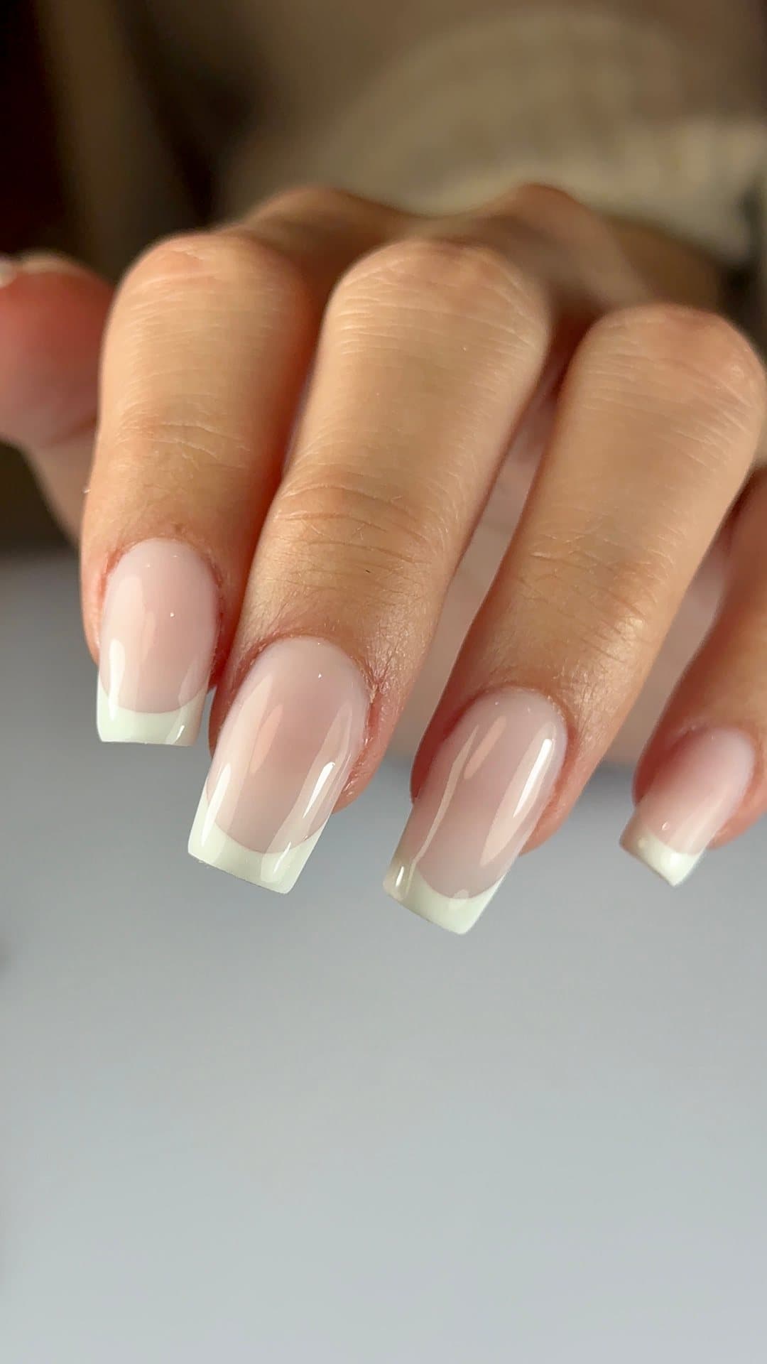 Manucure française sur ongles longs, base rosée naturelle et bords blancs, réalisée chez Gossip Concept.